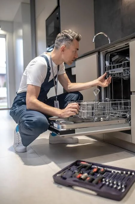 Appliance technician inspecting the interior of a dishwasher