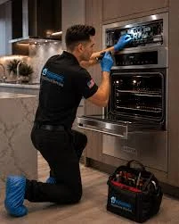 Technician inspecting the control panel of a built-in oven